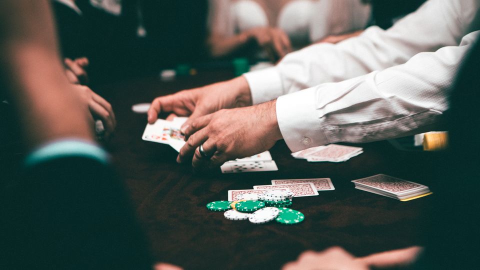 Pemain berkonsentrasi di meja poker dengan tumpukan chip