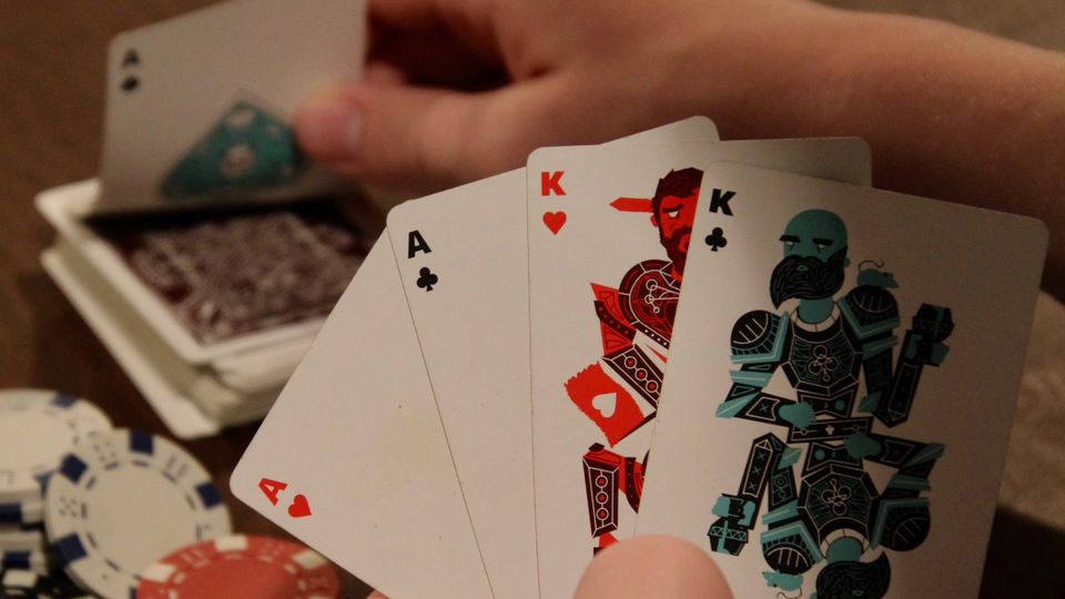 Kartu remi dan chip poker tersusun di atas meja